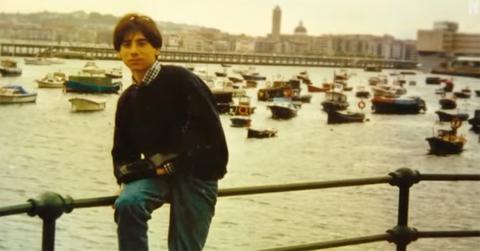 Alfredo Galán Sotillo sitting on railing next to a river and boats