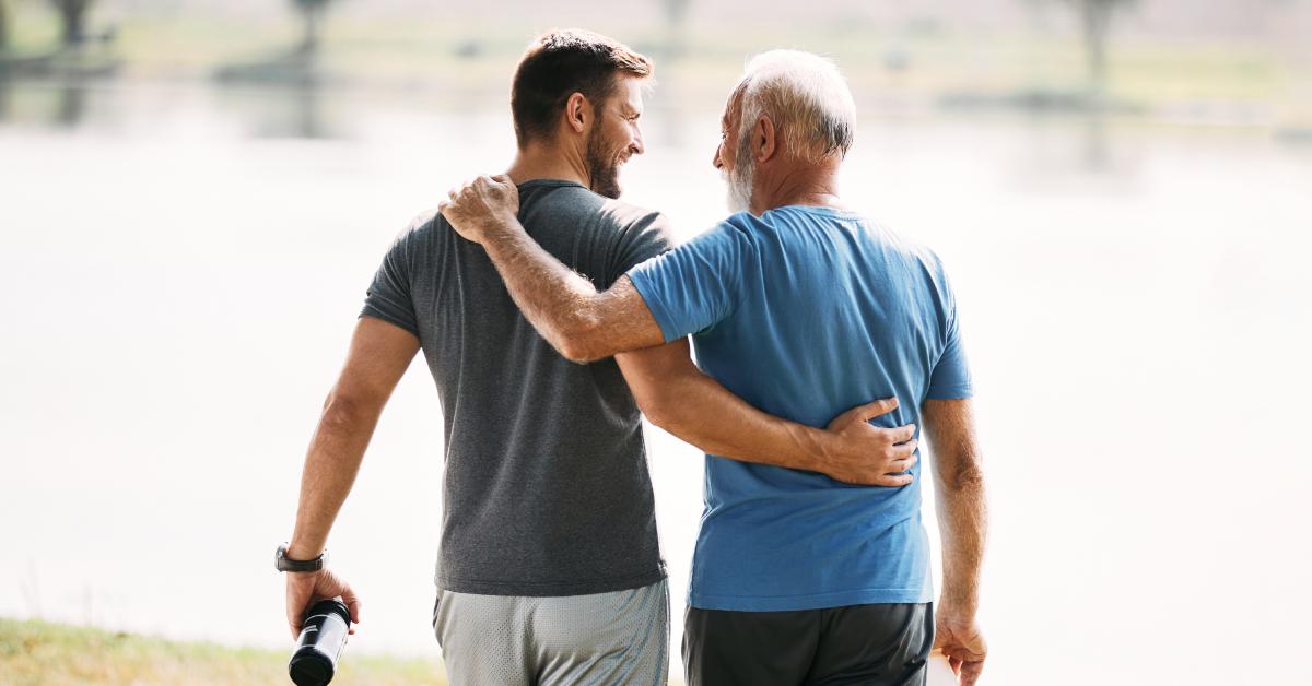 Two men walking near a lake.