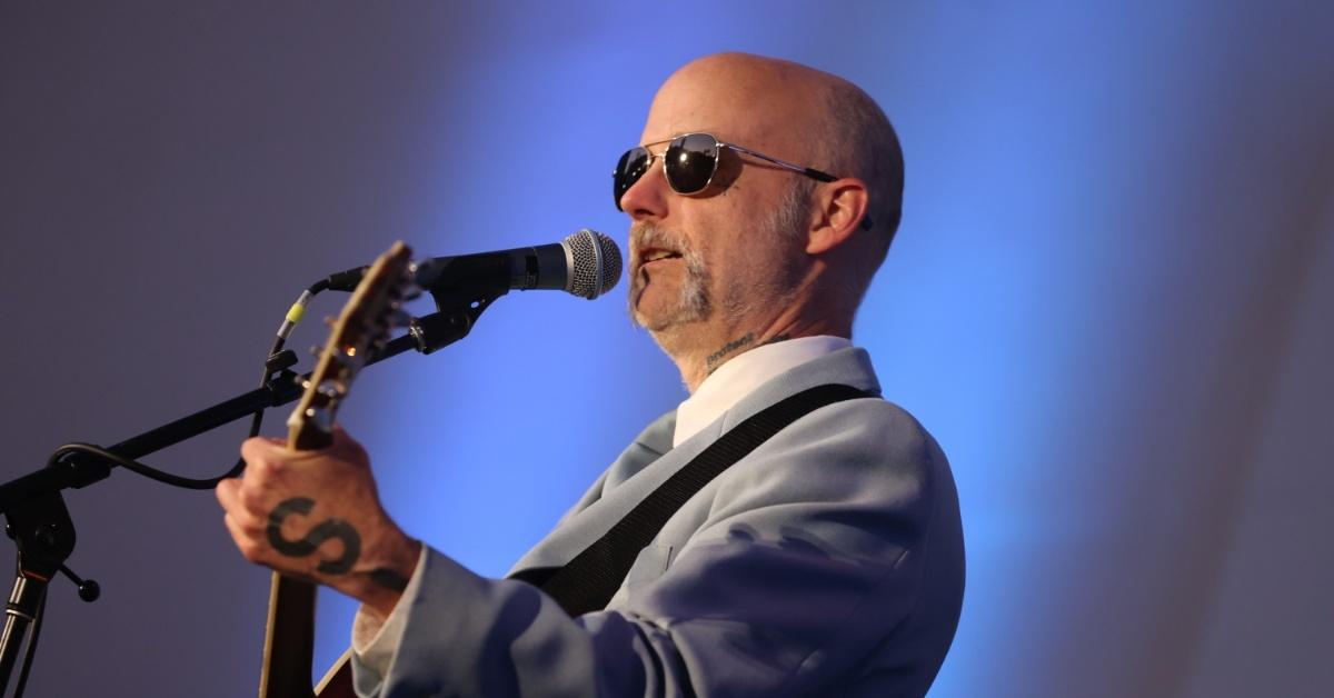 moby wearing sunglasses and playing guitar