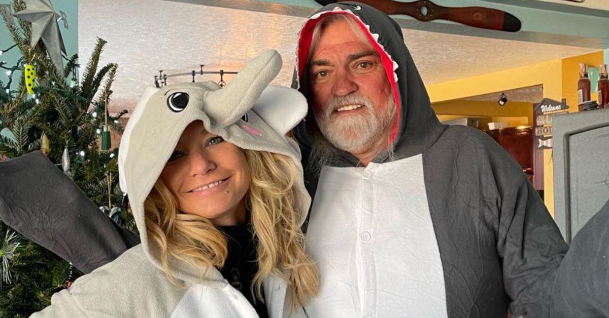 Shauna Scott and Captain Wild Bill Wichrowski pose for a Christmas photo together in animal onesies