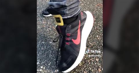 A red and black nike shoe with a buckle on the top.