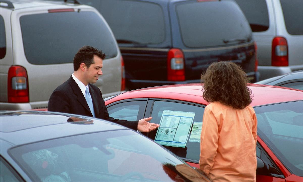 A woman and a car salesmen in a lot