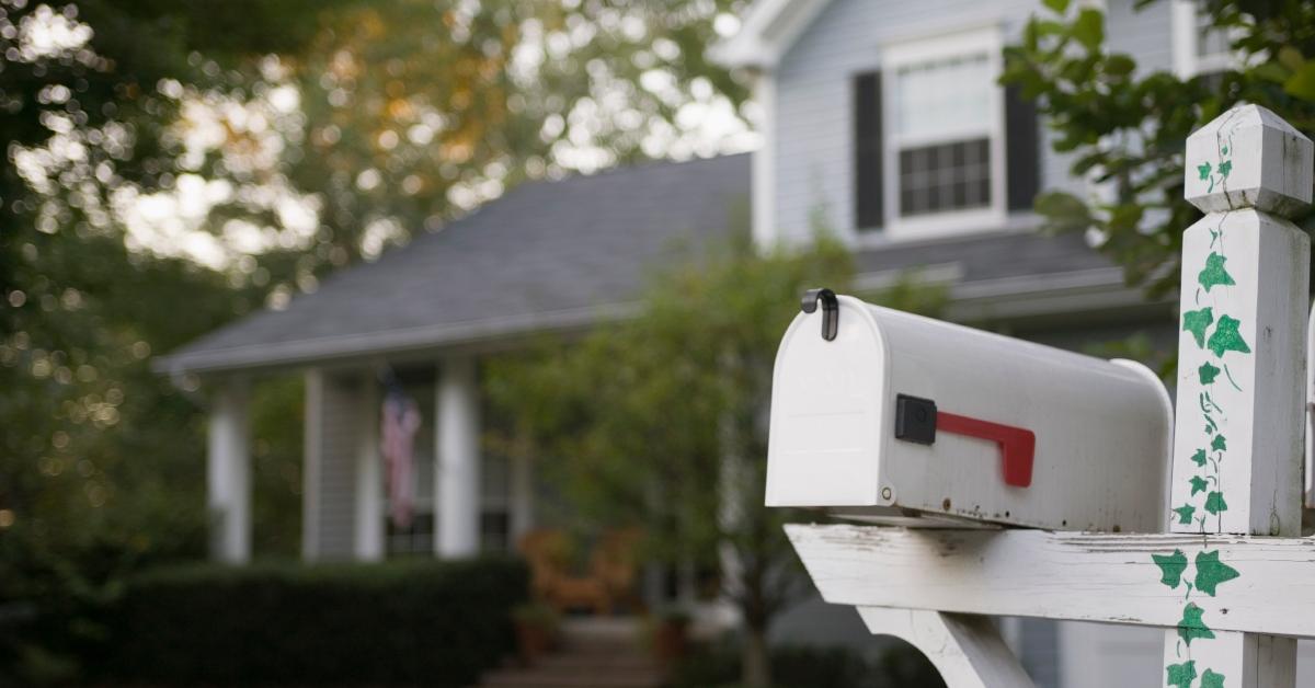 A mailbox on the curb in front of a house