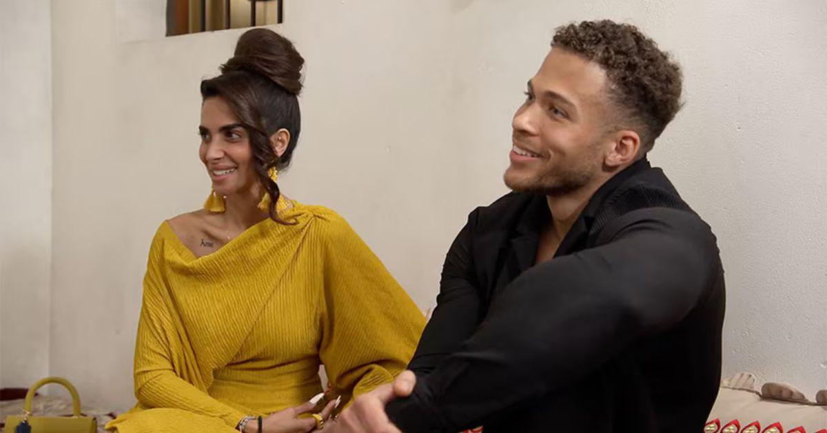 Sara Al Madani and Akin Fontana seated next to each other and smiling off camera on 'RHODubai'