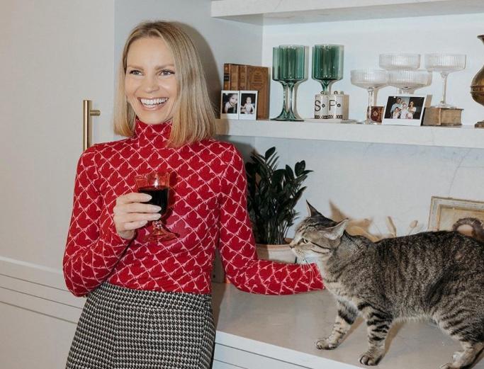 Monique Volz holding a glass of wine while petting her cat