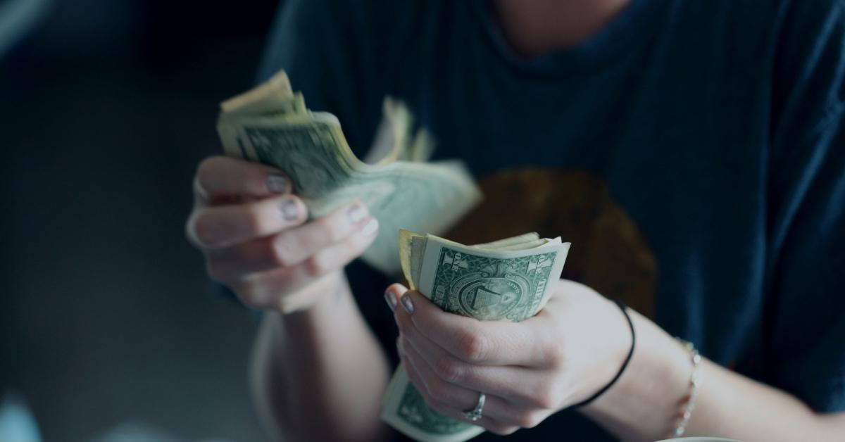 A woman counting dollar bills.