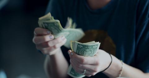 A woman counting dollar bills.