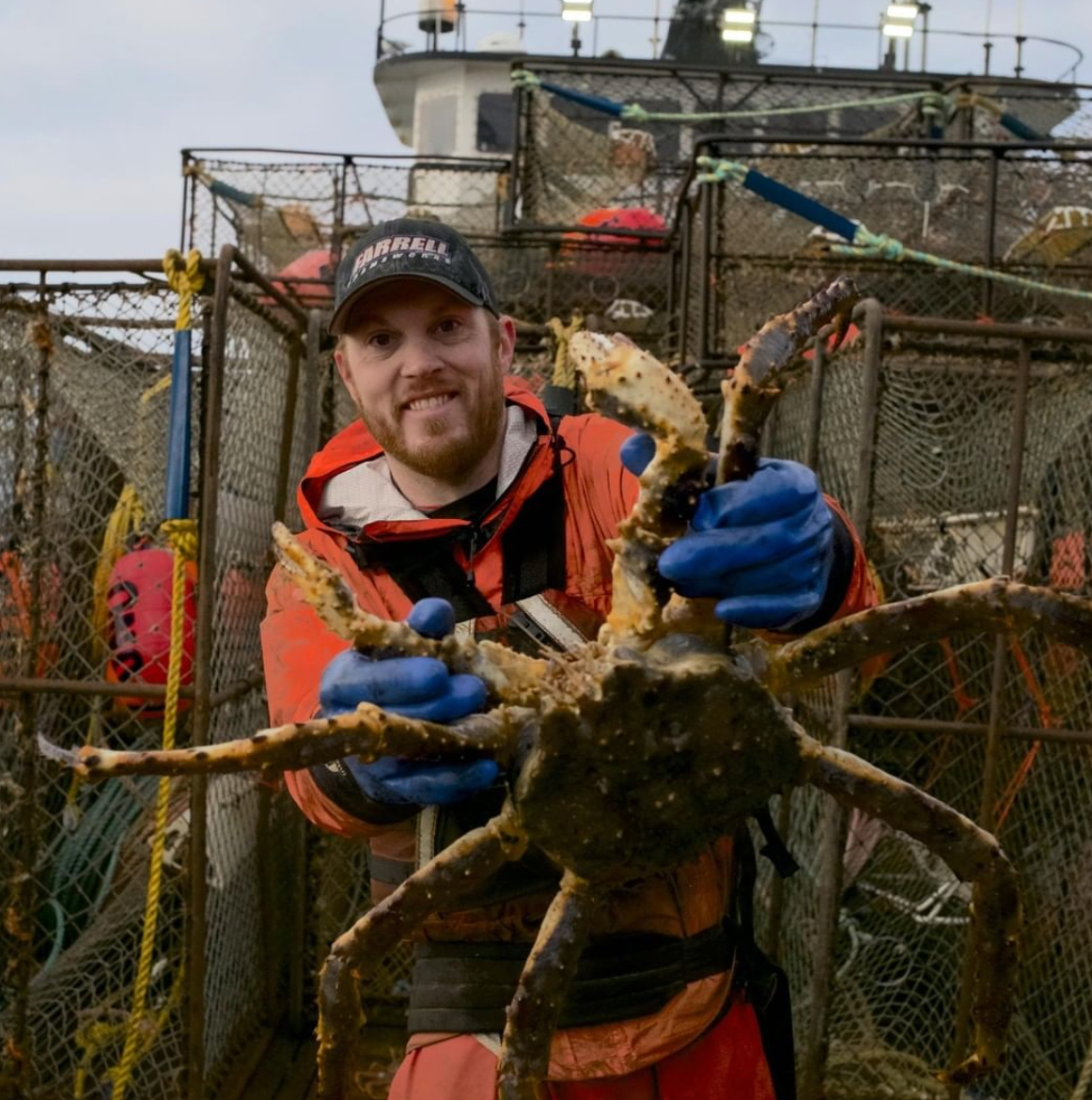 A crew member from 'Deadliest Catch' holding a live crab.