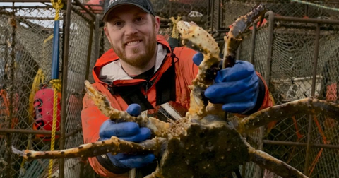A crew member from 'Deadliest Catch' holding a live crab.