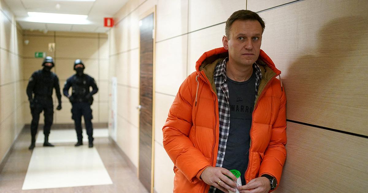 Alexei Navalny in a courthouse with two officers behind him. 