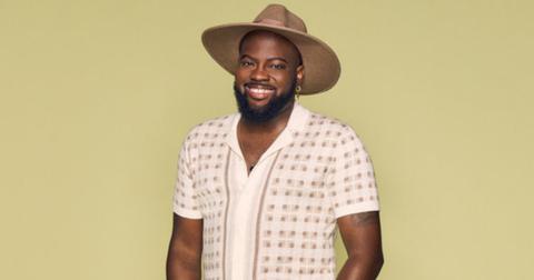 Preston Mitchum wears a short-sleeve sweater button up and a brown summer hat for his official 'Summer House: MV' Season 2 portrait.