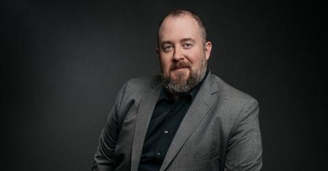 Judd Stone posing in a grey and black suit.