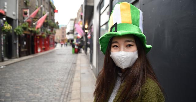 A person in a green and orange hat.