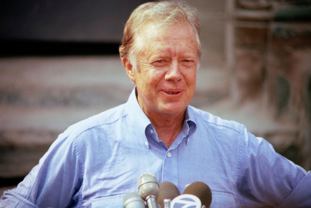 Jimmy Carter speaks to reporters during the renovation of a building on E 6th Street in 1984
