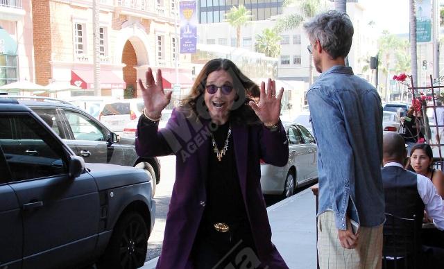 Ozzy Osbourne smiles on the street