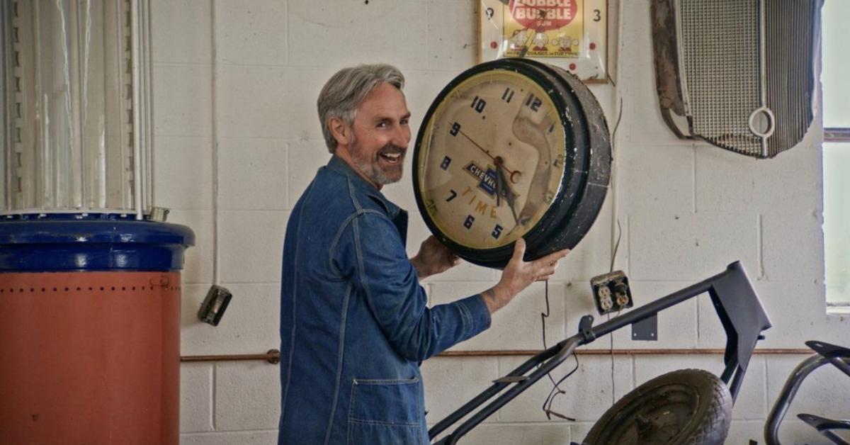 Mike Wolfe holding an antique clock on 'American Pickers'