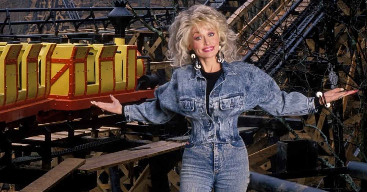 Dolly Parton in front of a coaster at Dollywood.