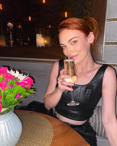 Alyssa Klinzing in black leather outfit holding a drink