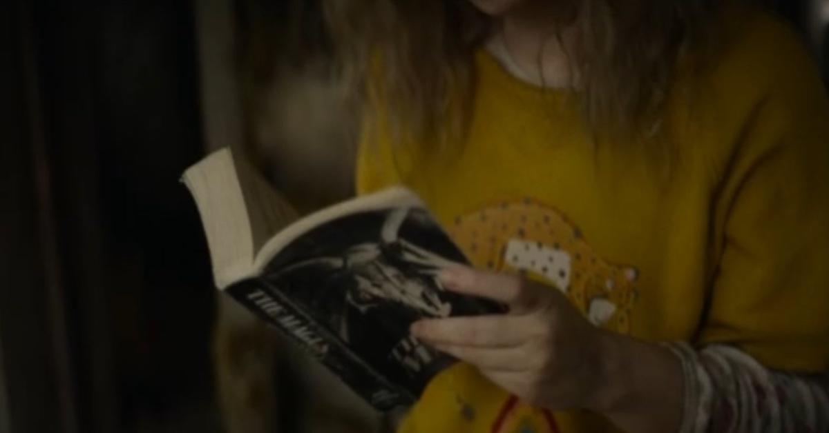 Misty (Sammi Hanratty) reads 'The Magus' in the cabin in 'Yellowjackets.'