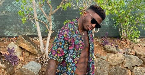 Tyreek Hill in a button down t-shirt and sunglasses.