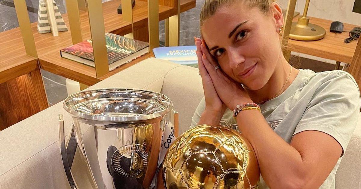 Alex Morgan cuddles her trophies in 2022