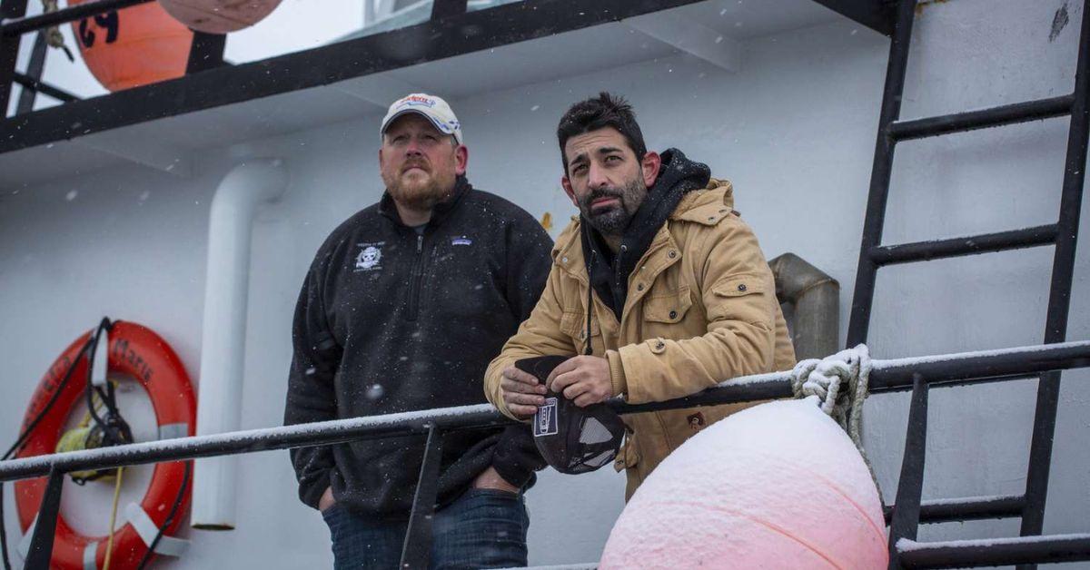 Casey McManus and Josh Harris looking out on the deck on Cornelia Marie in the middle of a light snow