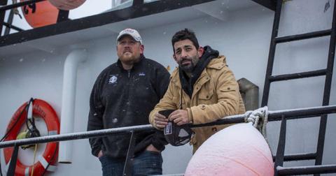 Casey McManus and Josh Harris looking out on the deck on Cornelia Marie in the middle of a light snow