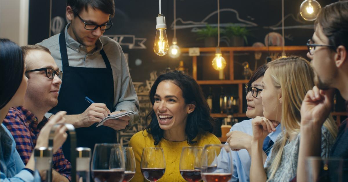 in the bar restaurant waiter takes order from a diverse group of picture id