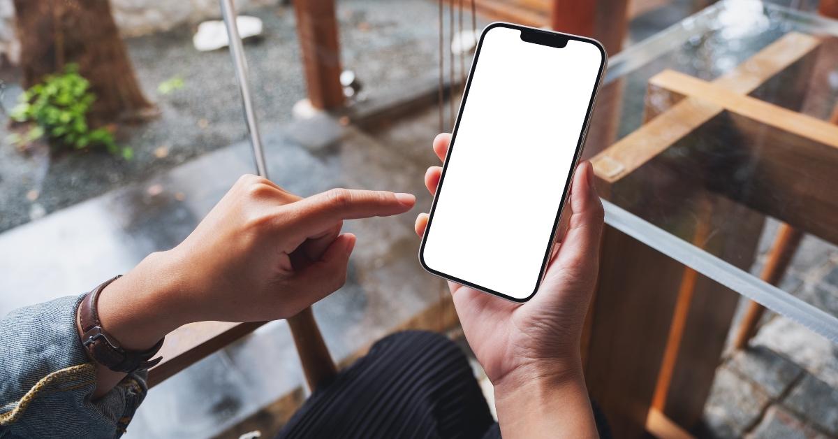 Person holding an iPhone with blank screen