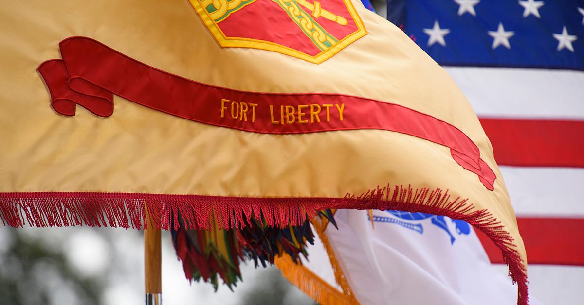 A flag that says Fort Liberty on it flowing in the wind. 