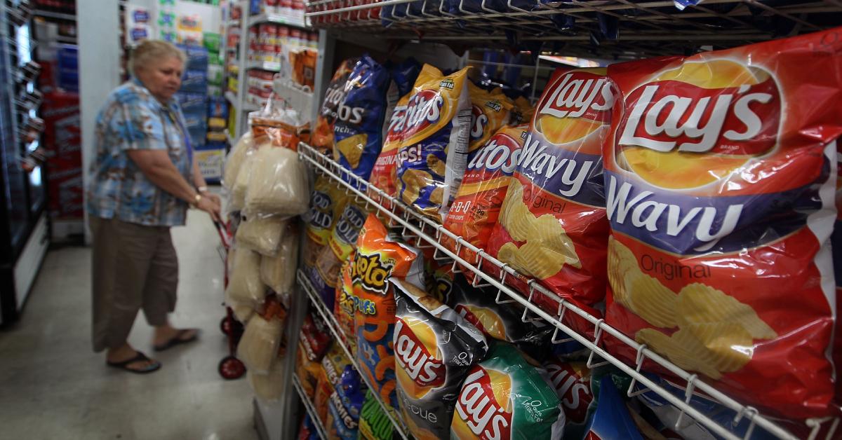 Bags of chips stocked on the shelves of a grocery store.