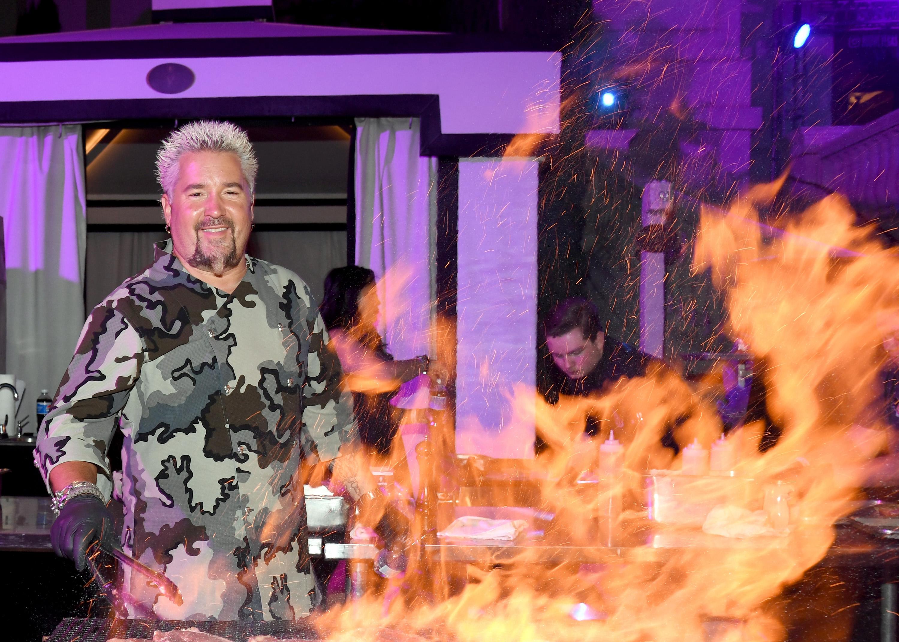 Guy Fieri prepares food at the Guy Fieri's Vegas Kitchen & Bar booth in 2018.