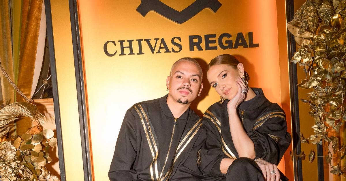 Evan Ross and Ashlee Simpson pose in front of gold Chivas Regal backdrop.