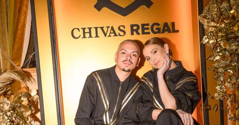 Evan Ross and Ashlee Simpson pose in front of gold Chivas Regal backdrop.