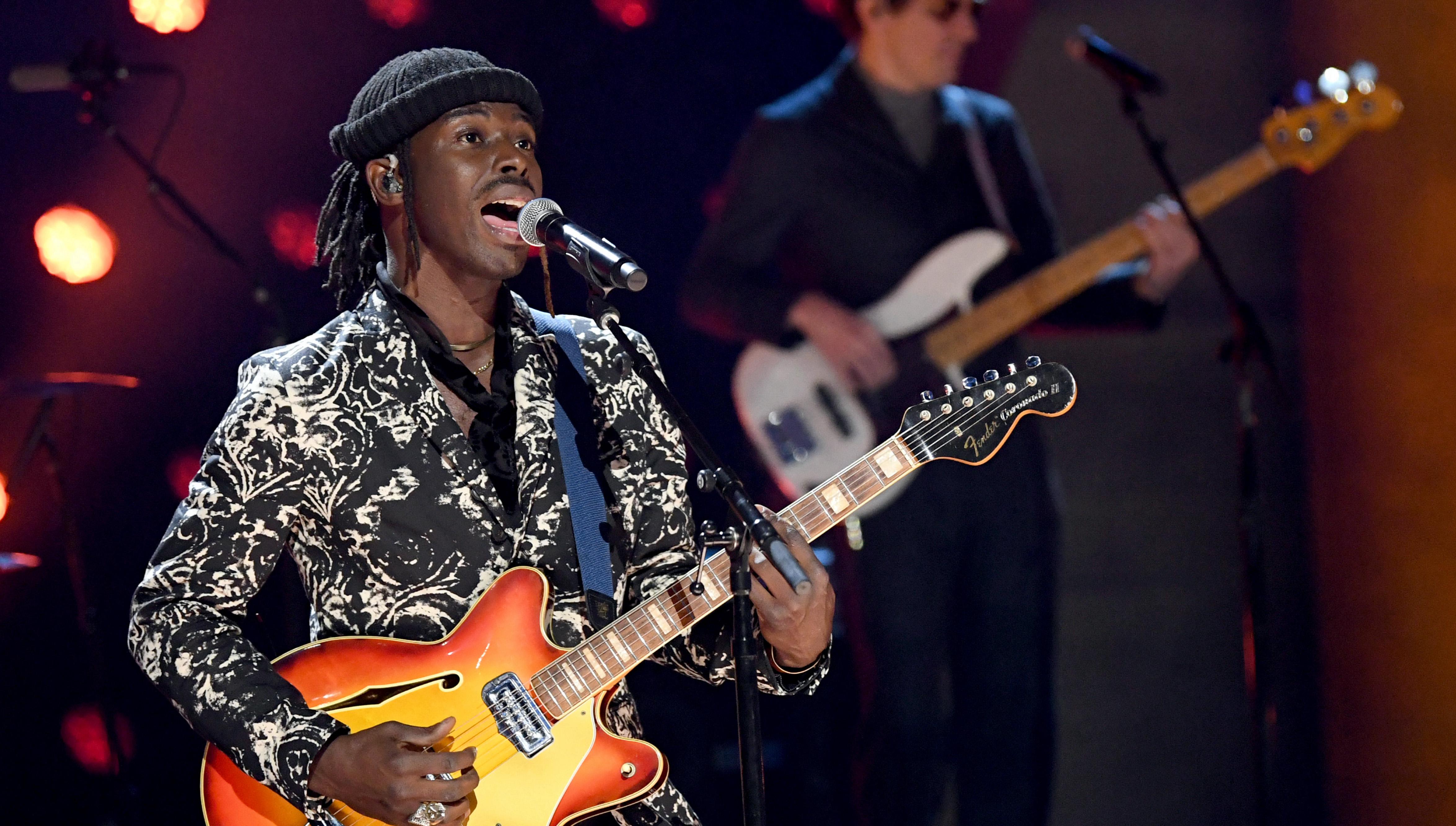 Eric Burton of Black Pumas performs onstage wearing an earpiece