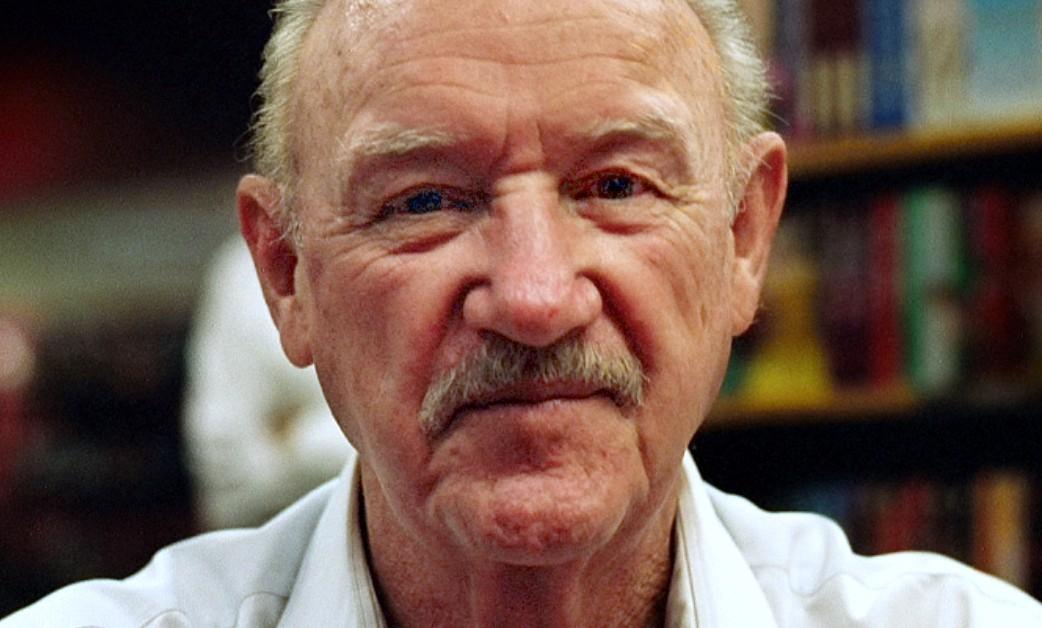 Gene Hackman in a library taking a photo