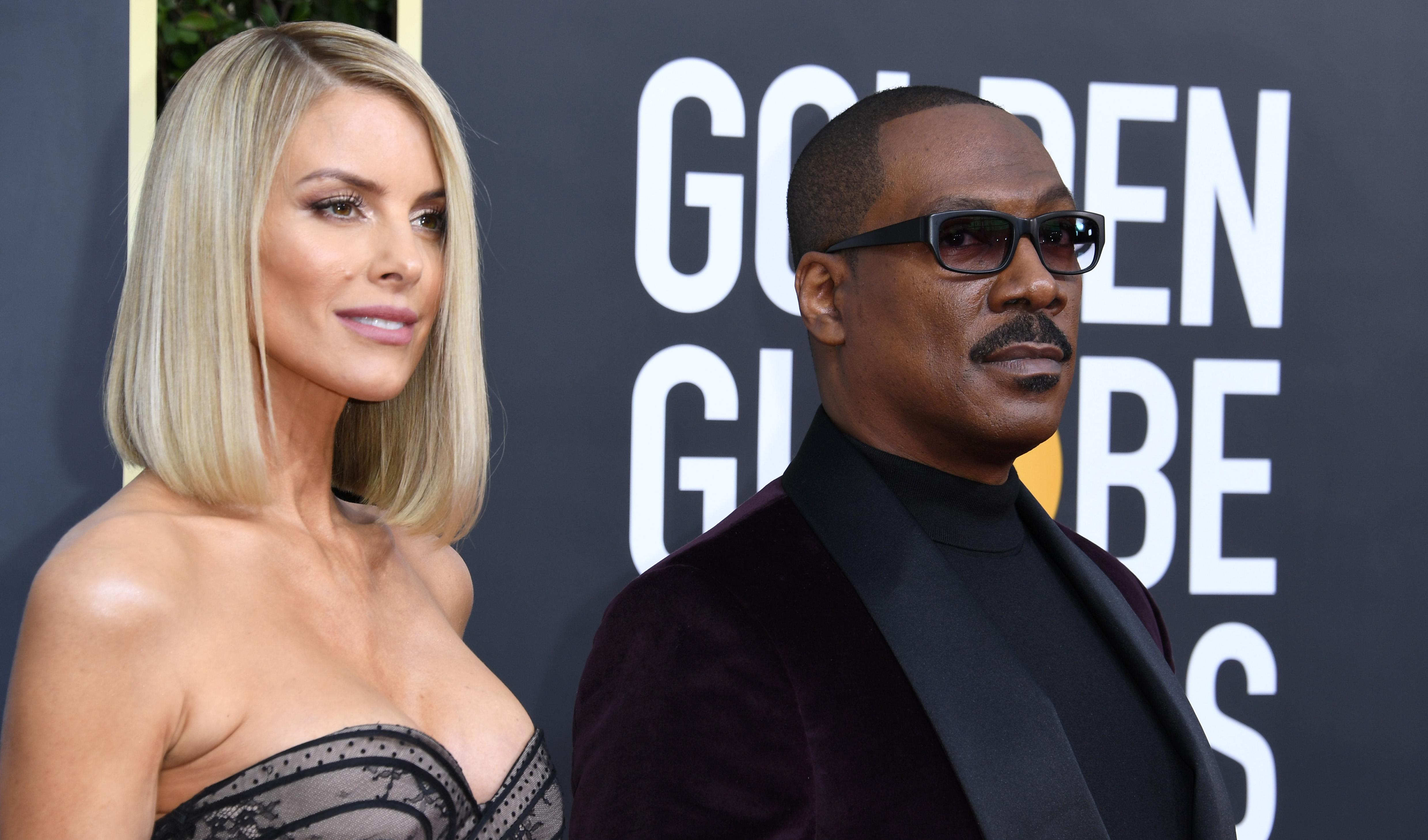 Paige Butcher et Eddie Murphy assistent à un événement sur le tapis rouge.