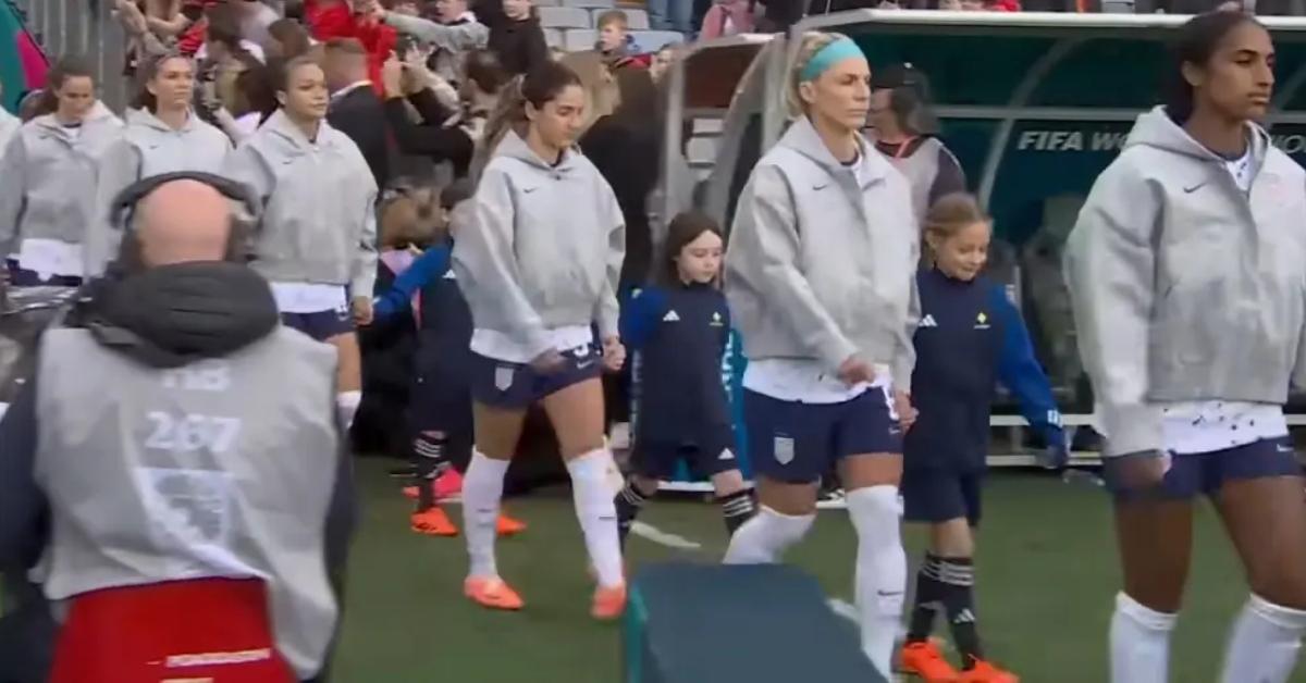 Soccer players walk out with kids who are referred to as “player escorts”