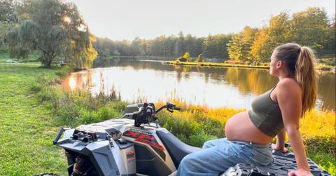 Nina sitting on an ATV with her baby bump