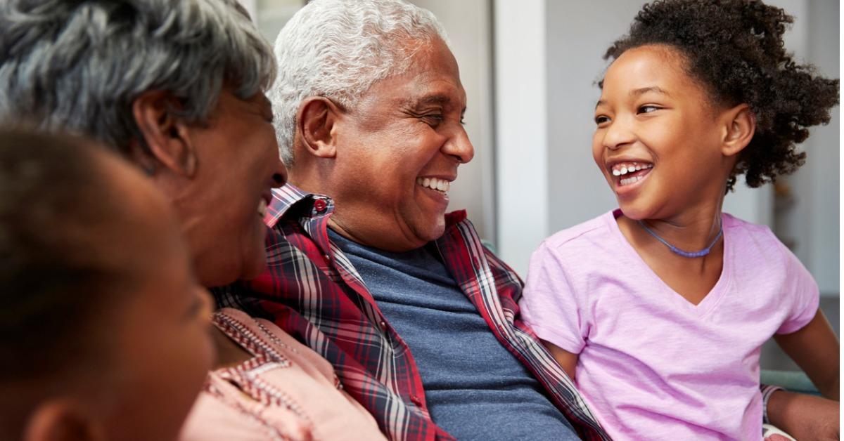 grandparents relaxing on sofa at home with granddaughters picture id