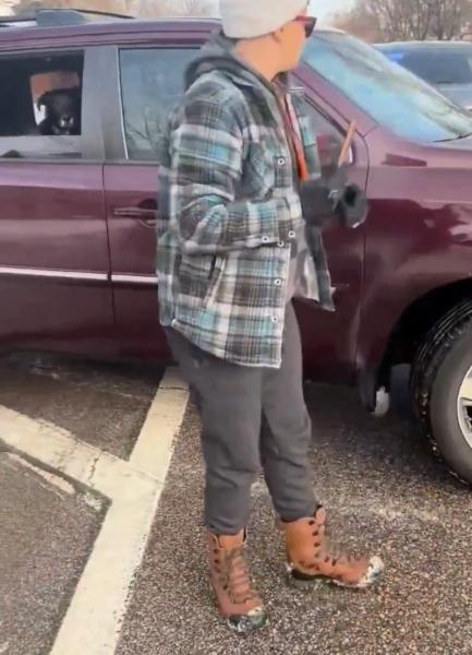 Renee Good's dog is seen in the backseat of her car with her wife standing outside of it.