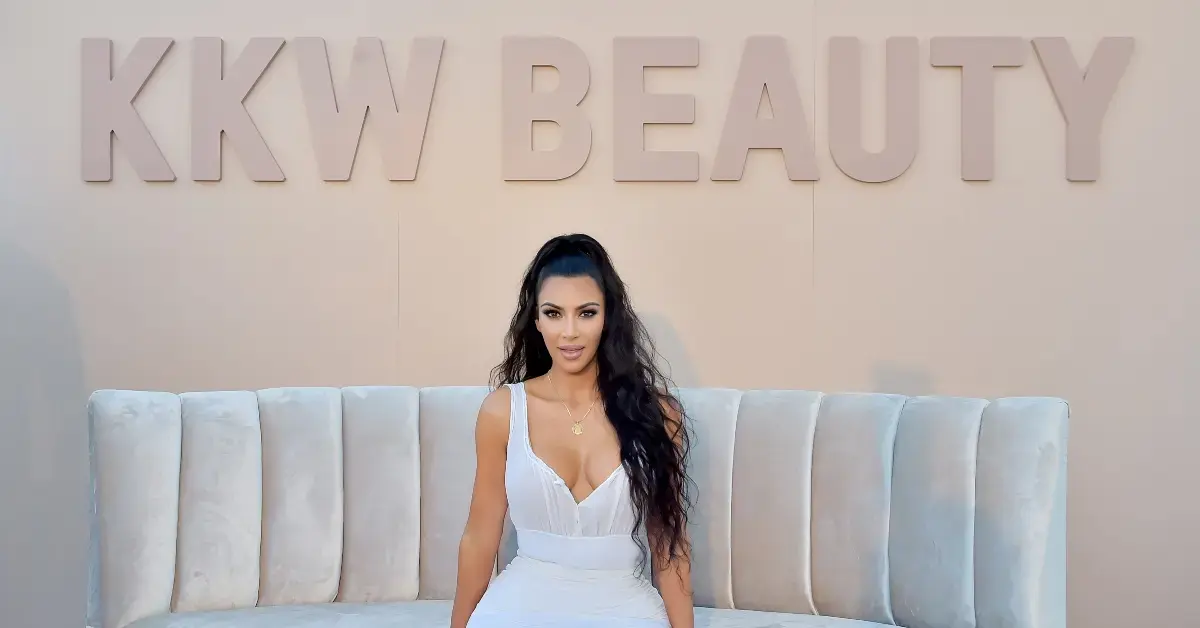 Kim Kardashian in front of a KKW Beauty sign