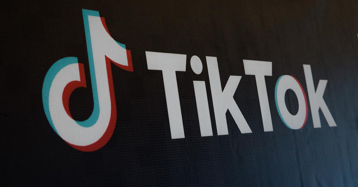 TikTok logo on a black wall. 