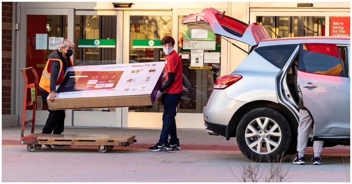 Target employees carrying a TV to a car