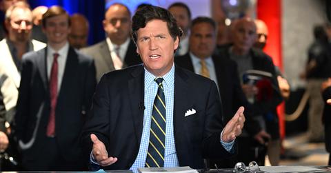 Tucker Carlson talking at a table during the 2022 Patriot Awards.