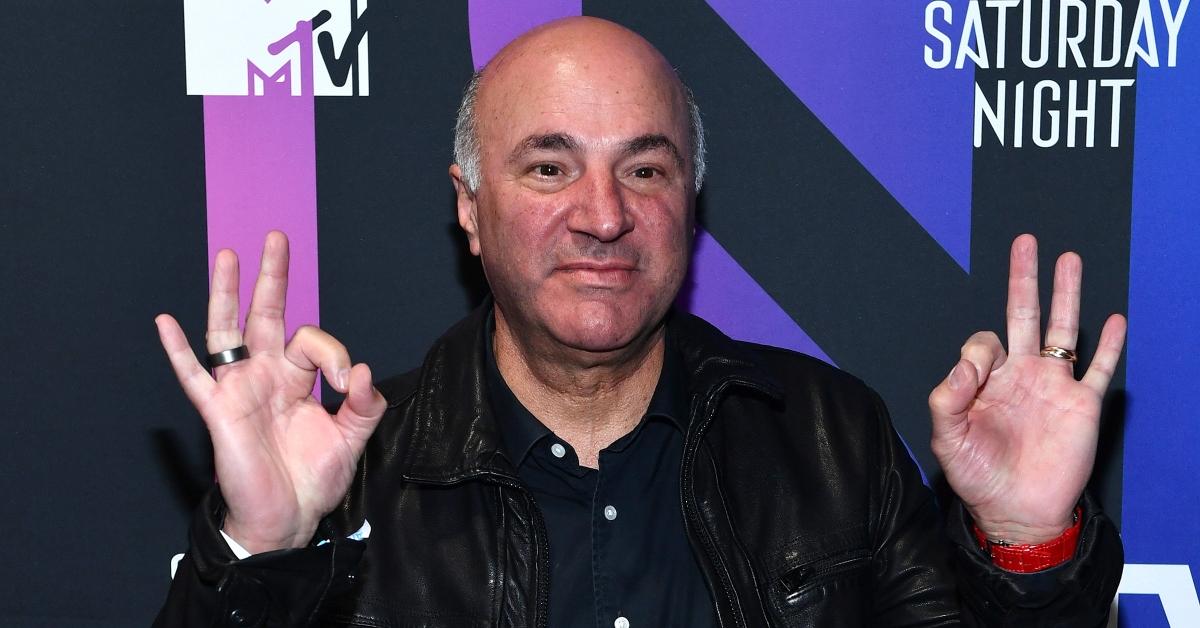 Kevin O'Leary posing in front of a pink, purple, and blue background at AT&T TV Super Saturday Night at Meridian at Island Gardens. 