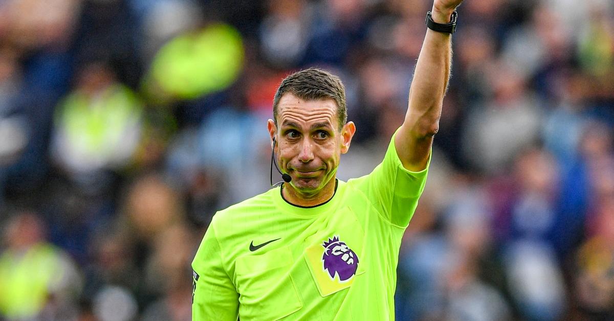 David Coote holds up a yellow card