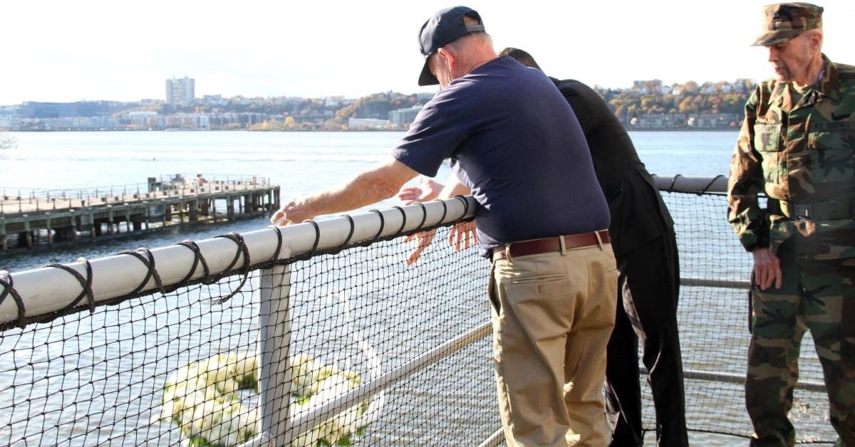 Veterans throwing a bouquet in the water at a Veterans Day celebration