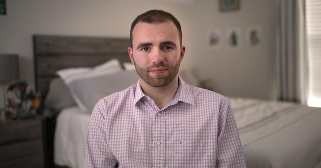 Connor Tomlinson poses for a portrait photo in his bedroom
