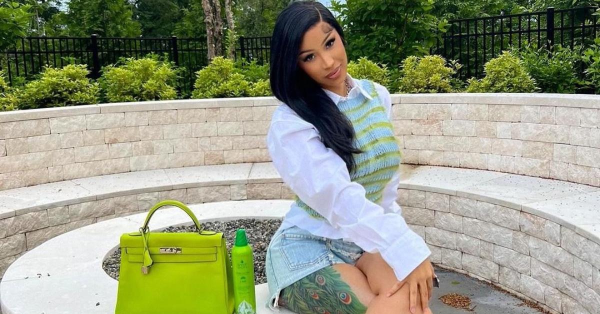 Cardi B sits outside on a stone patio